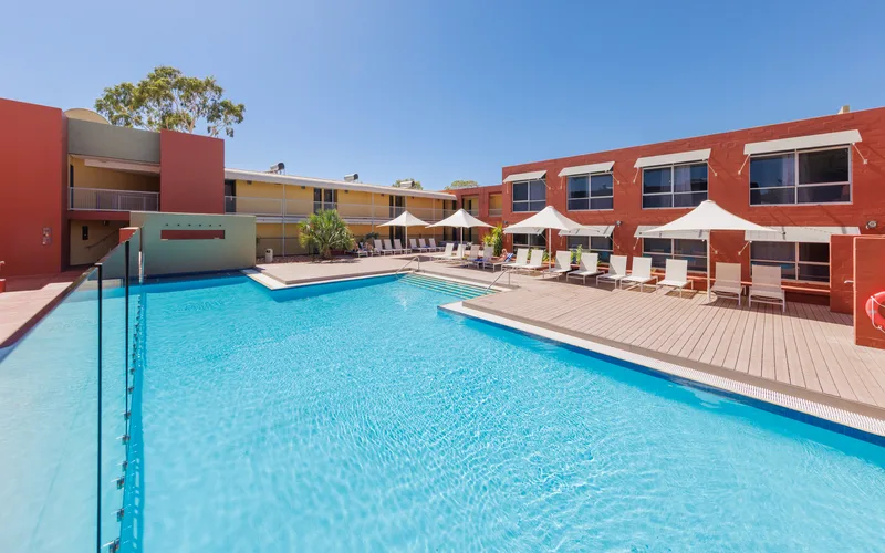 Swimming pool courtyard at The Lost Camel hotel in Yulara, the cheapest hotel base for Uluru tours, Northern Territory